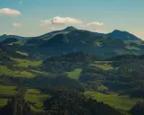 Wysokie Pieniny w jesiennej szacie, zielone pola i lasy tworzą malowniczy krajobraz.