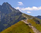 Szlak turystyczny w Tatrach Zachodnich wije się po zielonych zboczach i skalistych graniach.